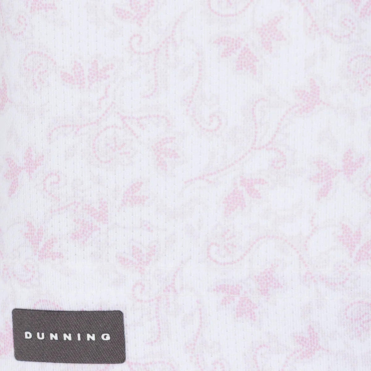Bennett Ventilated Performance Polo pink botanical print on white fabric with Dunning label, close-up