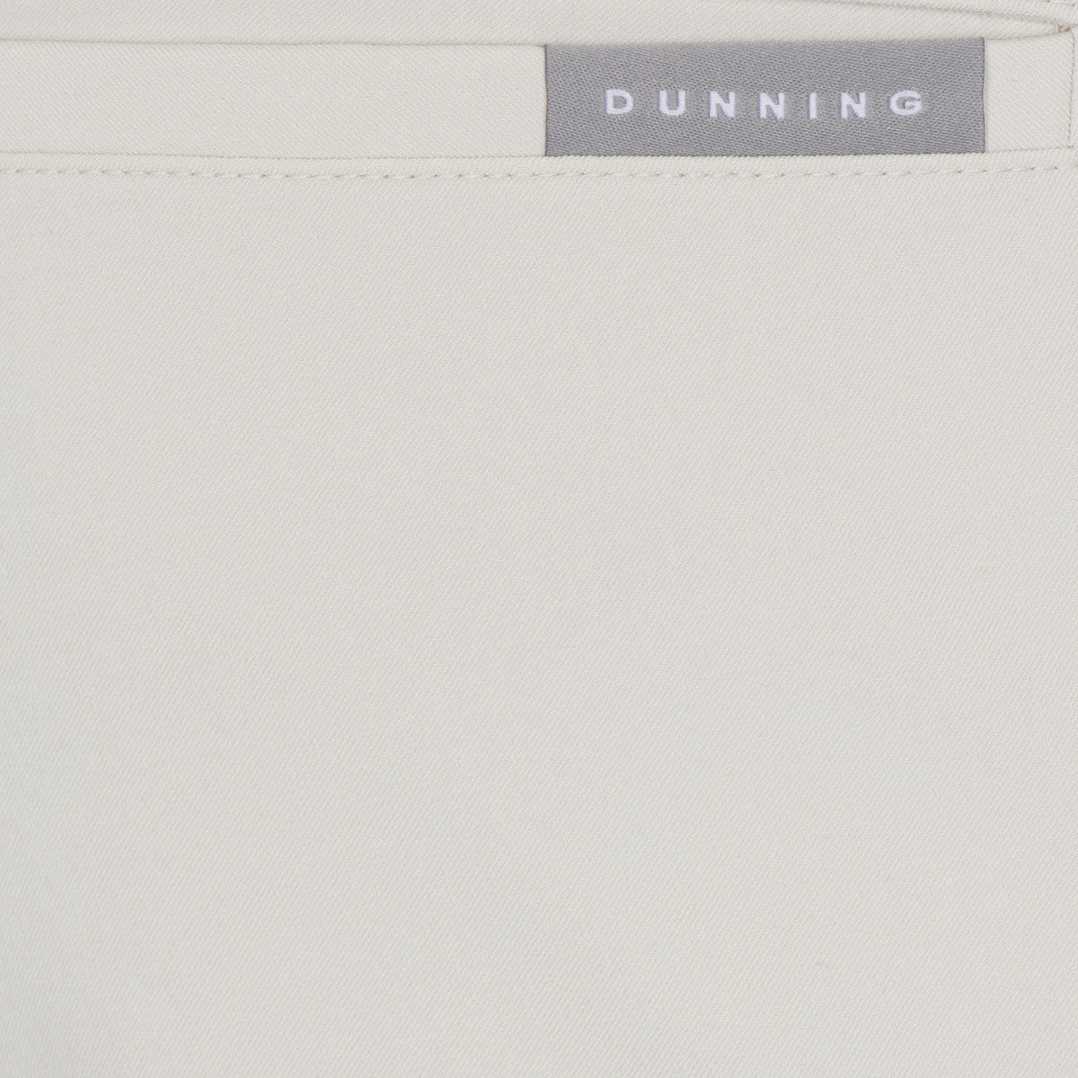 Close-up of a light gray fabric with 'Dunning' branding.