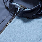 Close-up of a blue jacket with a zipper on a textured surface