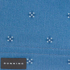 Close-up of a blue fabric with small white floral patterns and a 'Dunning' label.